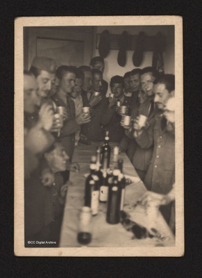 Uniformed men drinking together.