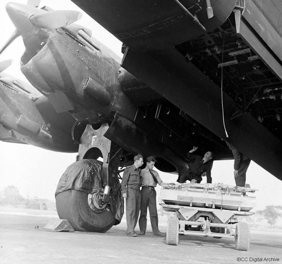 Airman and bomb trolley underneath a Halifax · IBCC Digital Archive