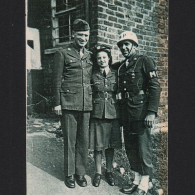 Two men and woman in front of a brick building