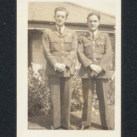 John Tait in front of a bungalow with an officer