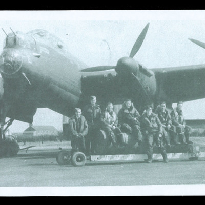 Aircrew with bomb trolley in front of Lancaster