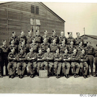 Thirty airmen in front of a wooden hut 