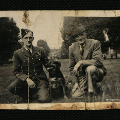 Two men kneeling with dog