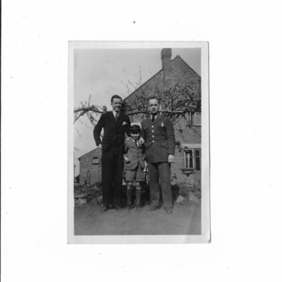 Two men and a boy standing in garden