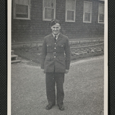 Airman standing in front of hut