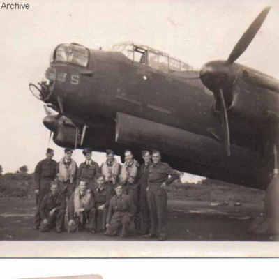 Eleven airmen in front of a Lancaster