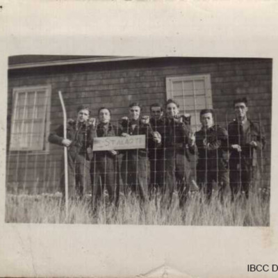 Seven airmen holding Stalag 12 sign