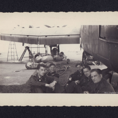 Airmen sitting by a Halifax
