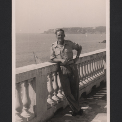 Charles Ward leaning on balustrade by the sea 