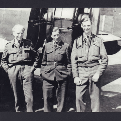 Three airmen standing by a Lancaster
