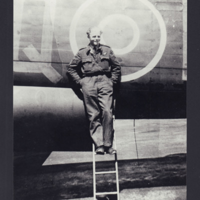 Airman standing on a ladder by a Lancaster