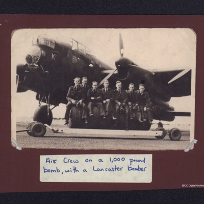 Air crew sitting on a 4,000 pound bomb, with Lancaster