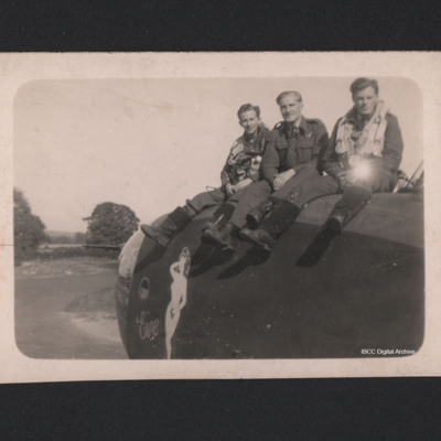 Three men sitting on the nose of a Halifax
