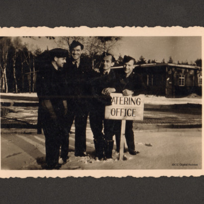 Four airmen by a catering office sign