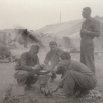 Men preparing food in tented camp
