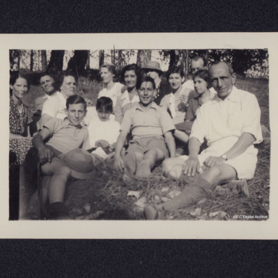 Group of adults and children sitting in woods
