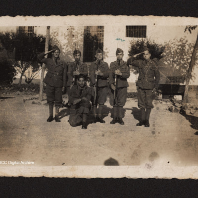 Six uniformed men standing in front of a building